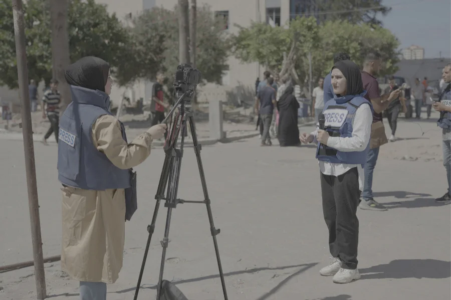 من اليمين: الصحفيتان أنسام القطة ونغم كراجة تُعدّان تقارير إخبارية من وسط مدينة غزة.