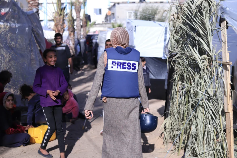الصحفية المستقلة هلا عصفور، المتعاونة مع فلسطينيات، تُعد تقريرًا عن معاناة الأطفال والنازحين في المخيمات قرب مجمع ناصر الطبي في خان يونس.